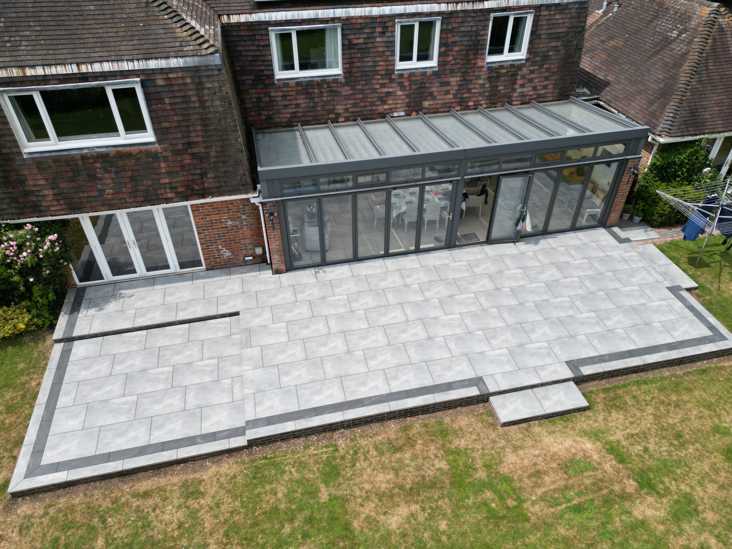 Porcelain Patio Installation Winchester Large porcelain patio with brick retaining walls in Winchester drone view