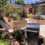 Raised red brick planting beds and beige porcelain patio in Winchester
